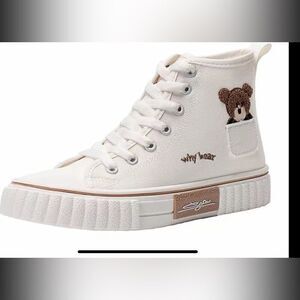 Cute white canvas sneakers with lil Bear peeking out .